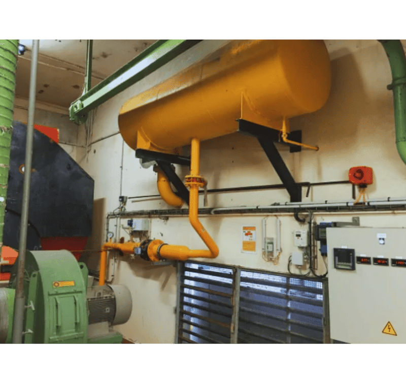 Installation industrielle avec un grand réservoir (ou capacité tampon) horizontal jaune et des tuyauteries.