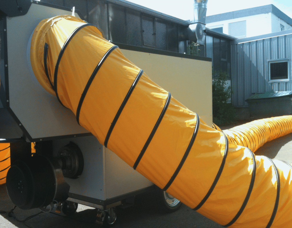 Générateur d'air chaud mobile avec une longue gaine de ventilation flexible jaune et noire.